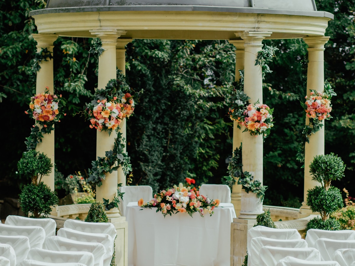 Mediterranean garden ceremony arch dressed with seasonal flowers